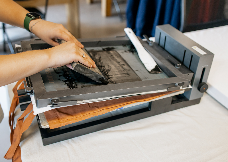 Fabric being screen printed manually